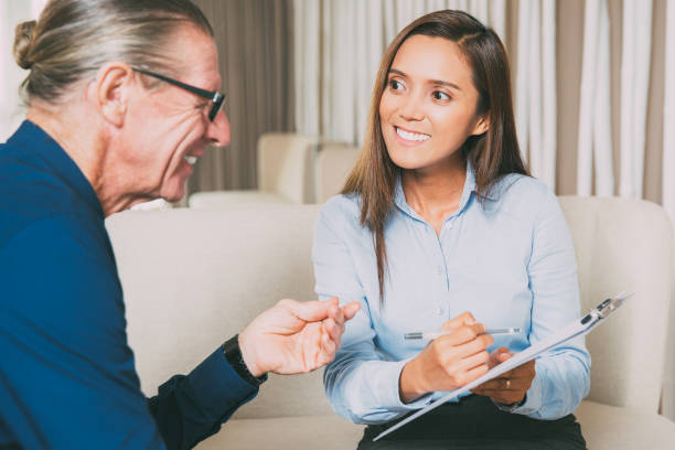 istock Smiling Young Woman Asking Senior Man Questions 645635974