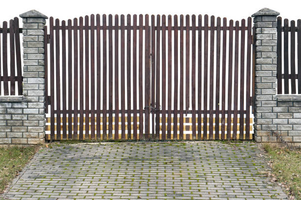 istock The thrown old wooden rustic gate with columns from granite bricks. Isolated on white. Cloudy day landscape 645638208