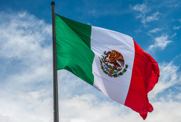istock Flag of Mexico over blue cloudy sky 645642884