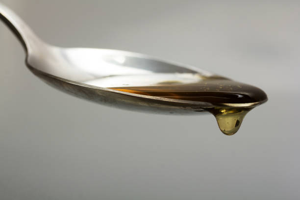 istock Honey pouring from spoon against a light background 645643276