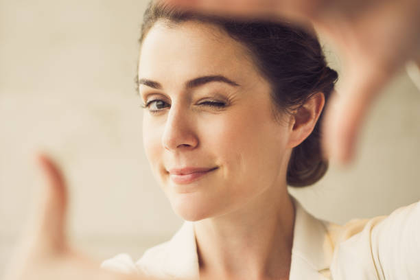 istock Closeup of Playful Woman Making Frame and Winking 645645998