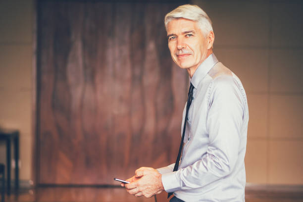 istock Serious Senior Businessman Using Smartphone 645646114