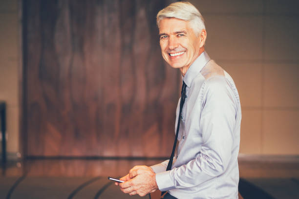 istock Smiling Senior Businessman Using Smartphone 645646154
