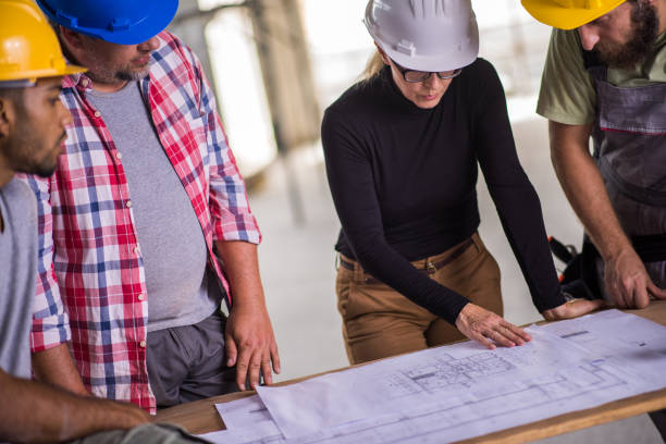 istock Group of construction workers reviewing plans 645656118