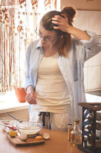 istock Kitchen disaster, bad cooking : confused woman and spilled egg 645663338