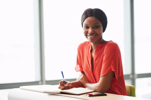 istock Black female writer looking into camera while wearing bright blouse 645667346