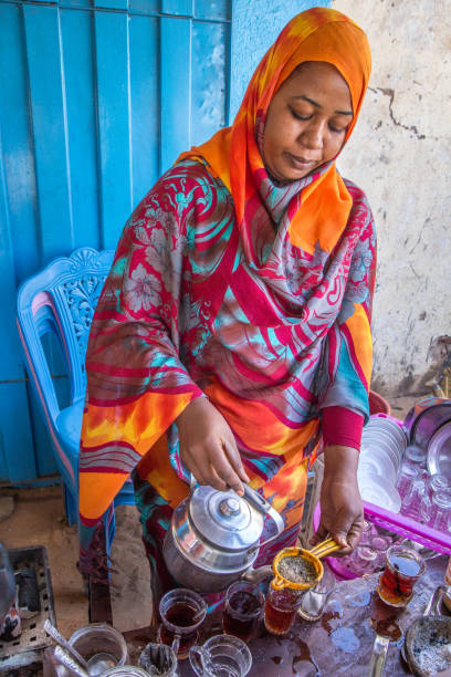 Sudanese woman pouring tea. Khartoum, Sudan - Dec 19, 2015: Portrait of a Sudanese woman pouring tea. khartoum stock pictures, royalty-free photos & images