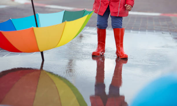 istock Kid in red boots with color umbrella on rainy day. 645673778
