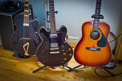 Newcastle-upon Tyne, private house collection of Gretsch and gibson electric and semi acoustic guitars on stands in front of an amplifier.