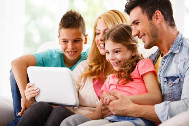 familia usando tableta digital juntos - two parent family technology mobility men fotografías e imágenes de stock