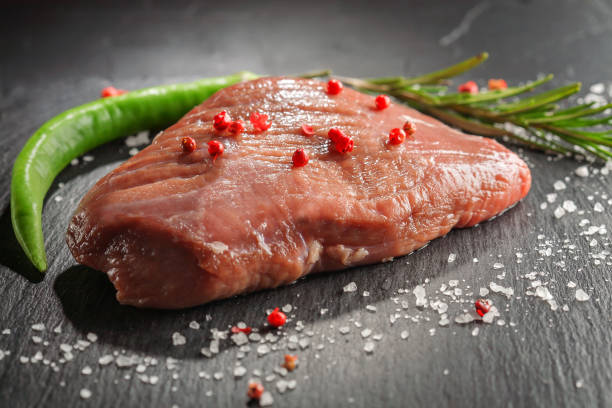 istock raw beef steak with rosemary and peppers on dark stone 645711608