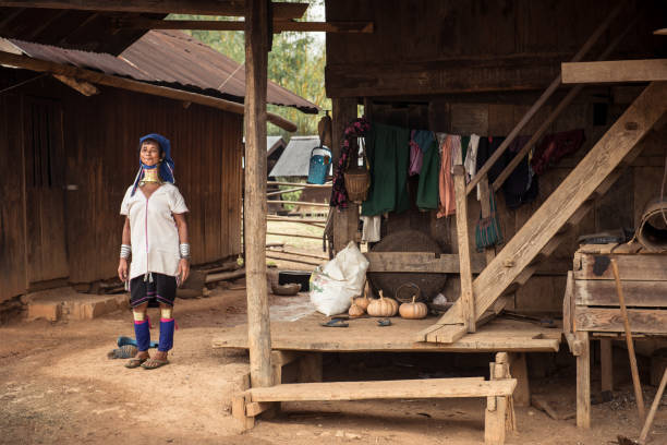 Rural life of Padaung hilltribes village in Myanmar Pan Pet, Myanmar - May 25, 2016: Rural life of Padaung (Karen) hill tribe village in Myanmar. Senior long neck woman in brass rings around her neck doing home work kayan neck rings stock pictures, royalty-free photos & images
