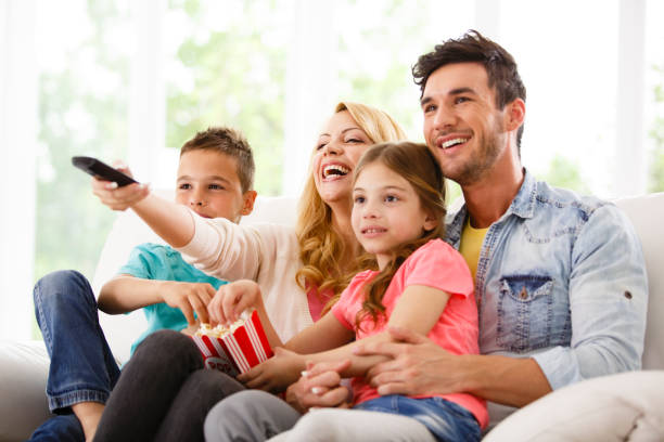istock Family watching TV on living room sofa 645720082