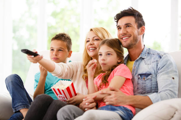istock Family watching TV and eating popcorn 645720508