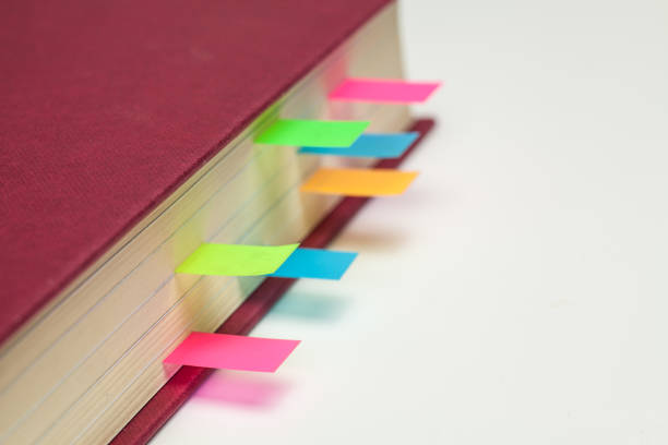 istock Coloured Sticky Page Markers in a text book 645723006