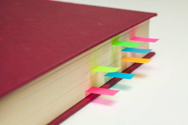 istock Coloured Sticky Page Markers in a text book 645723016