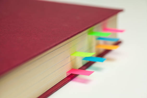 istock Coloured Sticky Page Markers in a text book 645723018