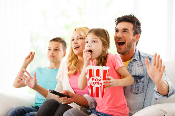 família, assistindo televisão, segurando a respiração - entertainment center watching tv television popcorn - fotografias e filmes do acervo