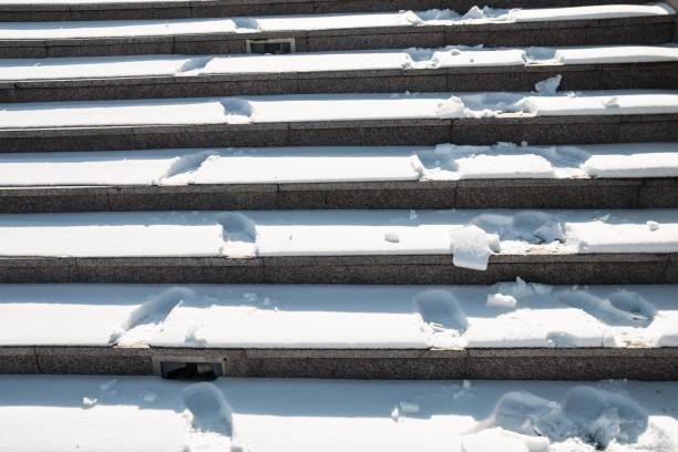 Iron steps covered with snow and fine gravel.
