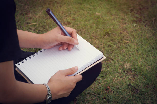 istock young girl 's hand writing on diary at filed 645727302