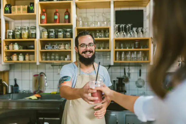 Photo of Bearded Man  serving smoothie to customer