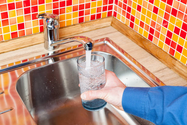 istock Filling up a glass with water from kitchen tap POV 645737646
