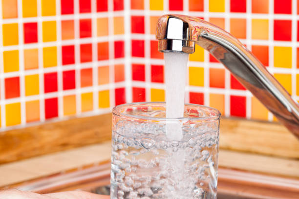 istock Filling up a glass with water from kitchen tap POV 645737654