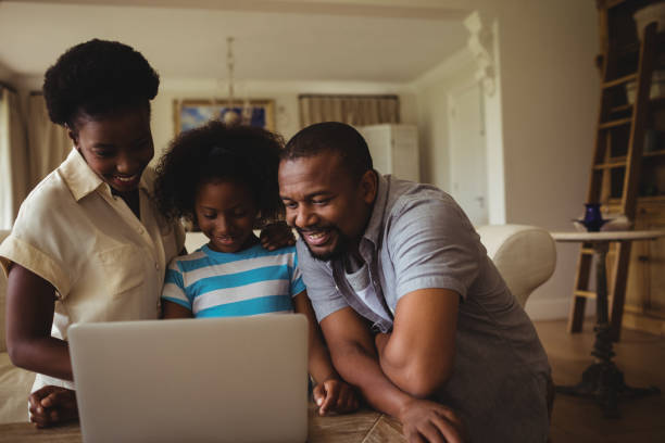 istock Parents and daughter using laptop in living room 645741182