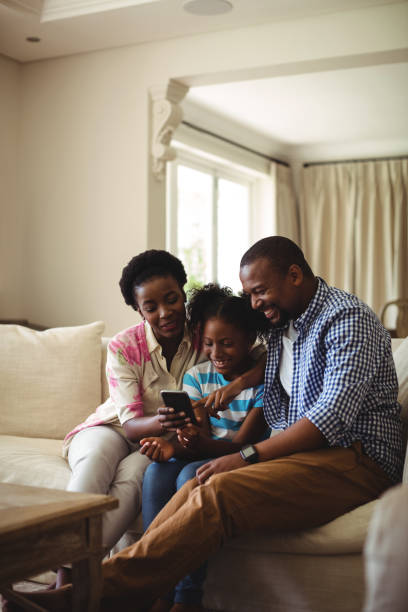 istock Family using mobile phone in living room 645742110