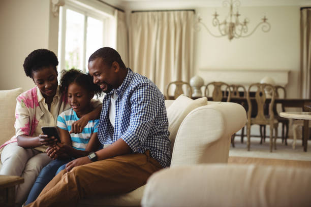 istock Family using mobile phone in living room 645742184