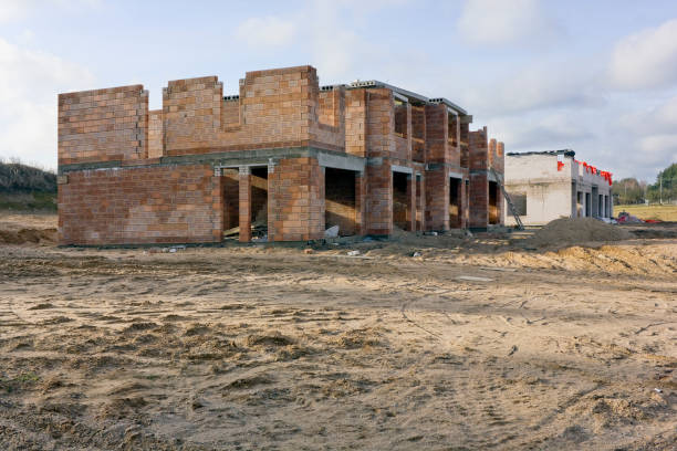 Construction red and white brick rustic style houses on sandy soil landscape