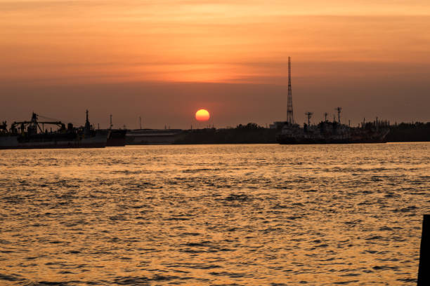 istock Wooden pier or jetty remains on sunset sky reflection water. 645749804