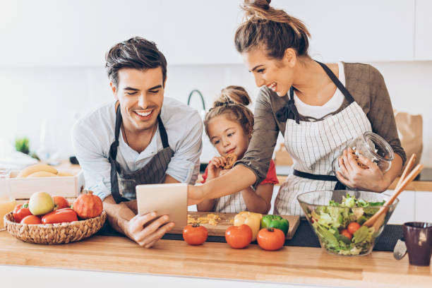 proviamo questa ricetta! - domestic life family heterosexual couple young family foto e immagini stock