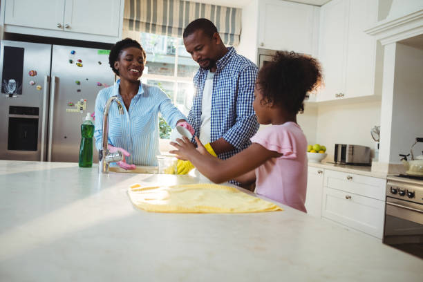 istock Family washing utensils in kitchen sink 645758700