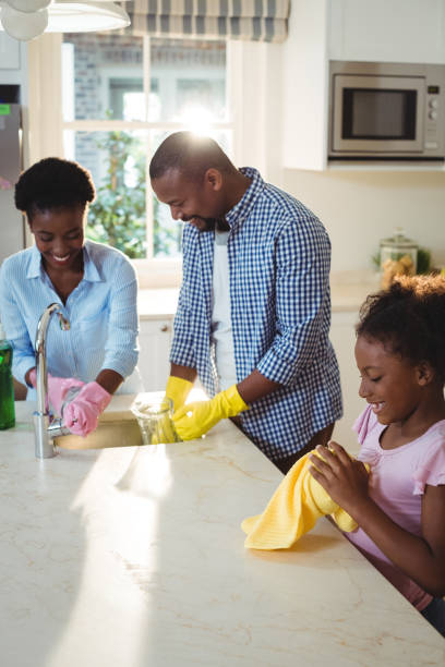 istock Family washing utensils in kitchen sink 645758732