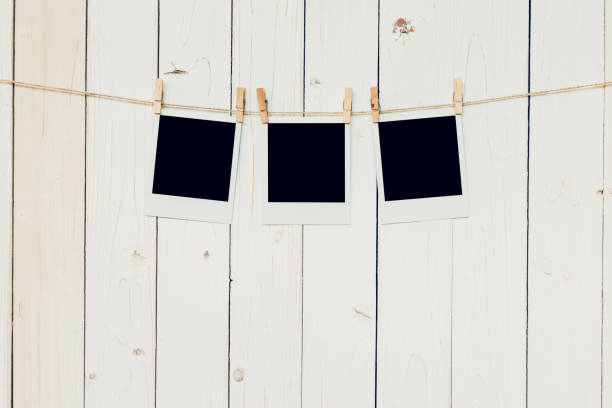istock Three (3)blank photo frame hanging on white wood background 645761472