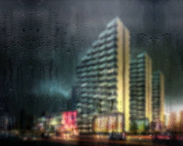 Rain Drops On Window With Defocused Buildings In The Background Digitally generated rain drops on window with defocused tall urban buildings in the background.

 kolkata night stock pictures, royalty-free photos & images