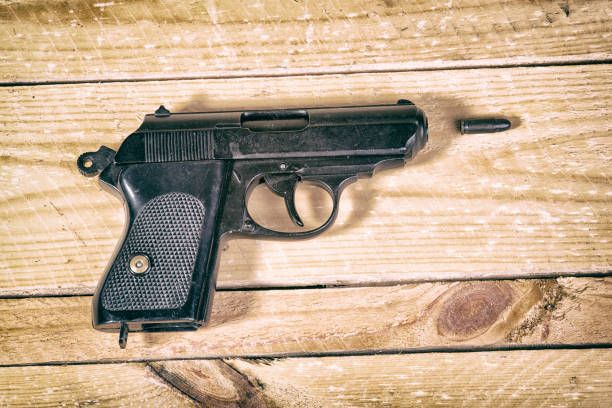 istock 9 mm gun and bullets strewn on the table. 645767834