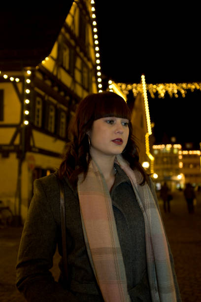 istock Young woman outdoors in town at night 645774356