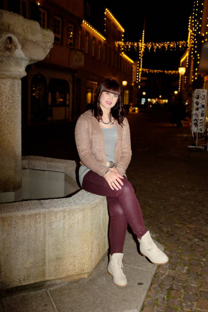 istock Young woman outdoors in town at night 645774376