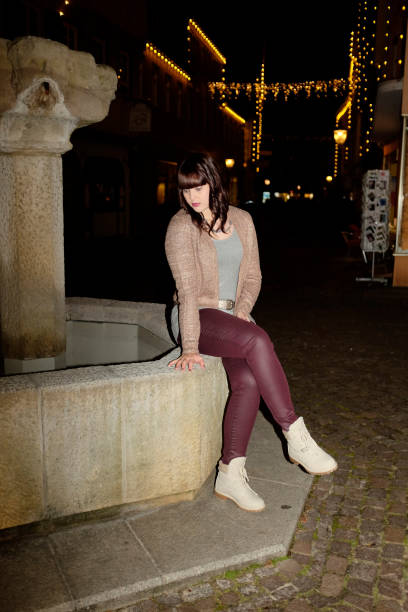 istock Young woman outdoors in town at night 645774892