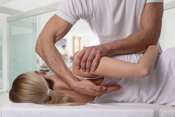 Woman having chiropractic back adjustment. Osteopathy, Alternative medicine, pain relief concept. Physiotherapy, sport injury rehabilitation stock photo