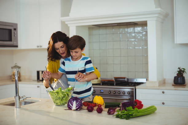 istock Mother and son mixing the salad in kitchen 645782286