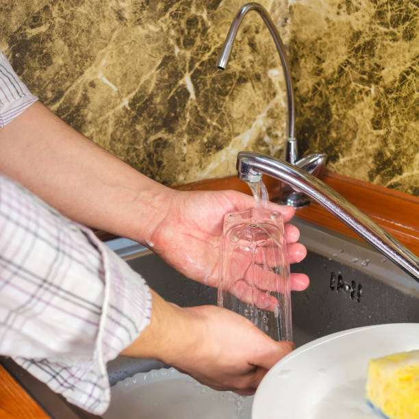 istock Man hands, washing a sponge with foam the dishes at the kitchen. 645785122