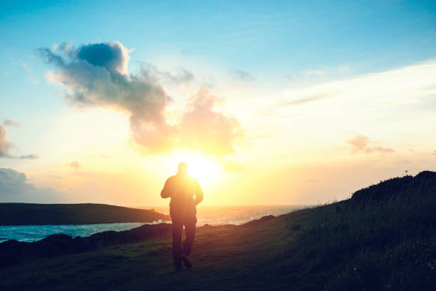 istock Man walking at Sunset, Pentire Headland, Newquay, Cornwall, September 645788268