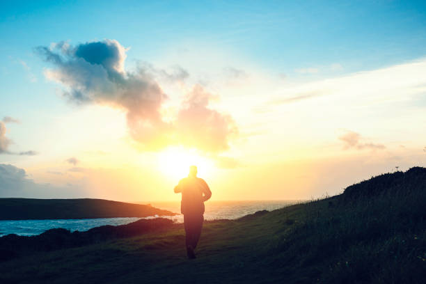 istock Man walking at Sunset, Pentire Headland, Newquay, Cornwall, September 645788276