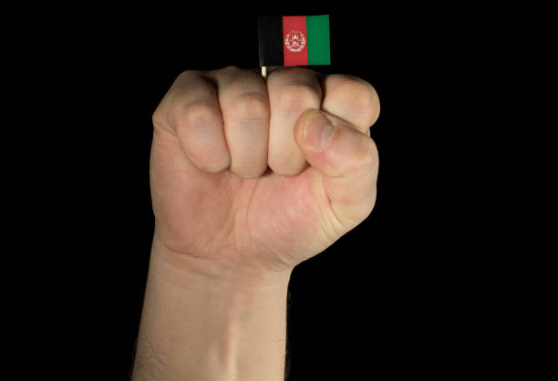 Man hand fist with Afghan flag isolated on black background