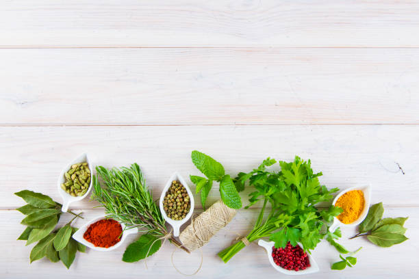 istock Fresh herbs and spices on a white wooden background 645794586
