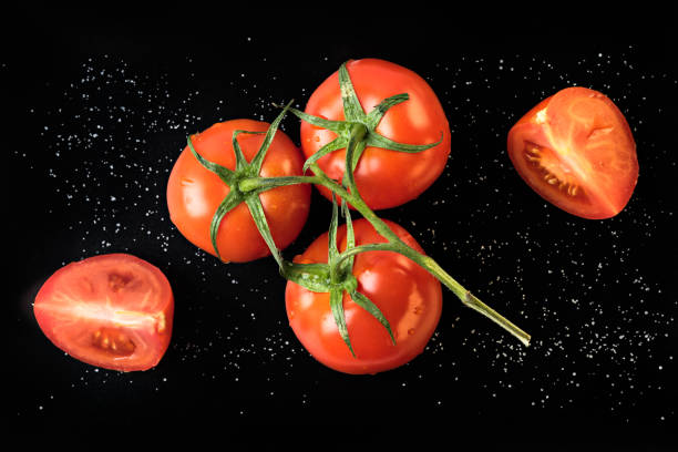 istock A branch of fresh red tomatoes on a black background. 645795202