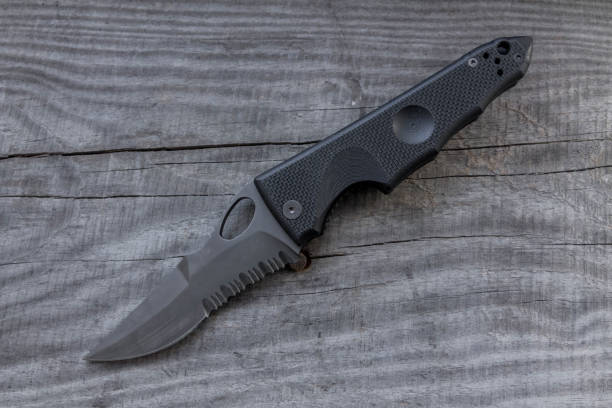 istock Knife with serrated blade for force on wooden background. 645795530